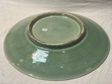 un bol vert bordé de brun posé sur une table