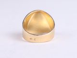 a close up of a gold ring on a white surface