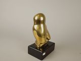 an image of a gold owl statue sitting on top of a black base