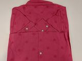 pink shirt on a hanger on a wall in a room
