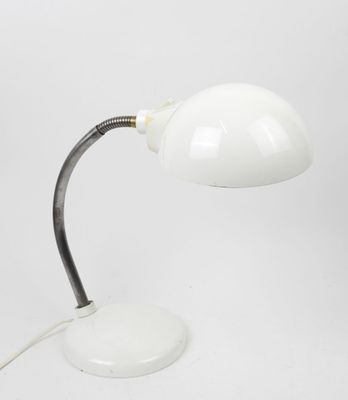 a close up of a white table lamp on a white surface
