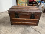 a brown trunk sitting on the ground in a garage