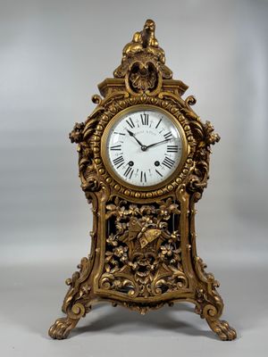 a gold clock that is sitting on a table