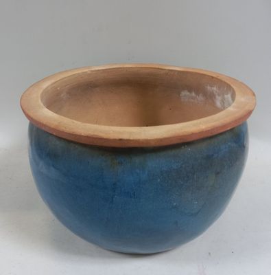 a blue bowl with a brown rim sitting on a white surface