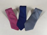 three ties are lined up in a row on a white surface