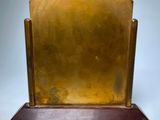 an image of a brass plate on a wooden stand