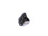 a close up of a ring on a white surface with a black stone