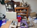 Des cartons contenant des objets divers sont posés par terre dans une pièce encombrée.