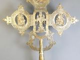 a gold cross with a picture on it on a table