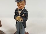 two figurines of a man with a top hat and a cane