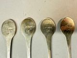 four spoons are lined up in a row on a table