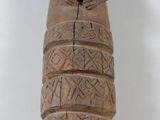 statue d'une femme en robe, réalisée en bois, posée sur un fond blanc