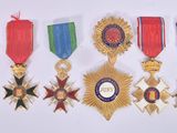 several medals are displayed on a white surface with red, blue, and green ribbons