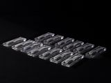 un gros plan sur six barquettes en plastique transparent posées sur une surface noire