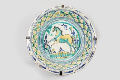 une photo d'une assiette décorative sur laquelle figure un cheval