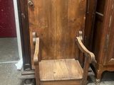 une chaise en bois posée devant une armoire en bois