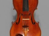 an old violin sitting on top of a table next to a gray wall