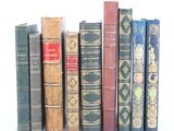 plusieurs vieux livres sont alignés sur une surface blanche