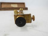 an antique brass plated telescope with a wooden box in the background