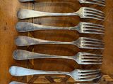 six forks on a wooden table with a knife and fork
