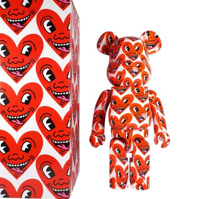 un ours en peluche rouge et blanc et une boîte en forme de cœur rouge et blanche
