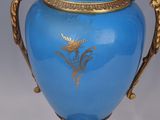 a blue vase with a gold decoration on it
