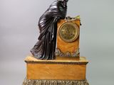 a statue of a woman sitting on top of a clock
