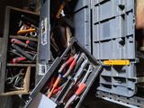 de nombreux outils dans une boîte à outils posée par terre