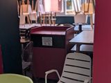 des chaises et des tables aux couleurs vives dans un restaurant aux murs rouges