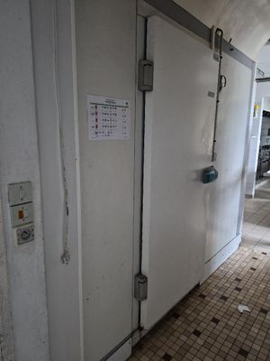 une porte donnant sur une salle de bains sur laquelle est accrochée une pancarte