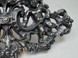 a silver brooch with a picture of a man and a woman on it