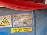 une image montrant un gros plan d'un tuyau rouge sur une machine bleue