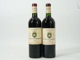 deux bouteilles de vin posées l'une à côté de l'autre sur une surface blanche