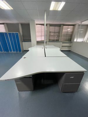 un bureau dans une pièce équipée d'armoires bleues et d'un bureau blanc