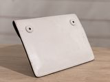 white leather ipad case on a wooden table with a white brick wall in the background