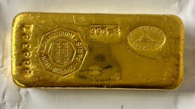 gros plan d'un lingot d'or sur une surface blanche