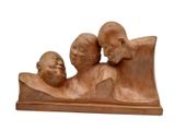 une sculpture représentant trois personnes assises sur un banc