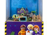 un gros plan sur une figurine Playmobil représentant trois personnes devant un bâtiment