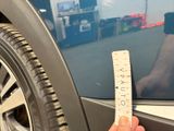 a person holding a ruler in front of a car