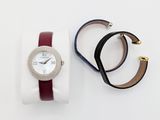 un gros plan d'une montre-bracelet et d'un bracelet posés sur une surface blanche