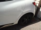 a small white car parked on the side of the road