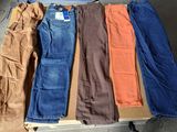cinq paires de jeans disposées sur une table