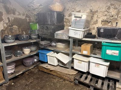 de nombreuses casseroles et poêles sur les étagères de la pièce