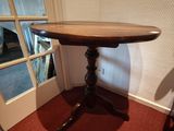 une petite table avec un plateau en bois posée sur un tapis rouge