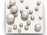 a lot of silver balls floating on a white surface