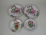 three plates with flowers on them sitting on a white surface