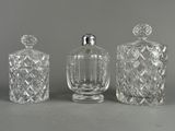 trois bouteilles en verre transparent posées les unes à côté des autres sur une table