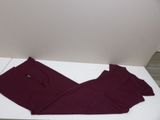 maroon pants on a white table with a white wall in the background