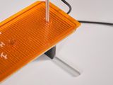 a close up of an orange light on a white surface