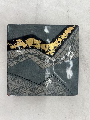 carreau carré noir et doré orné d'un motif de feuilles d'or